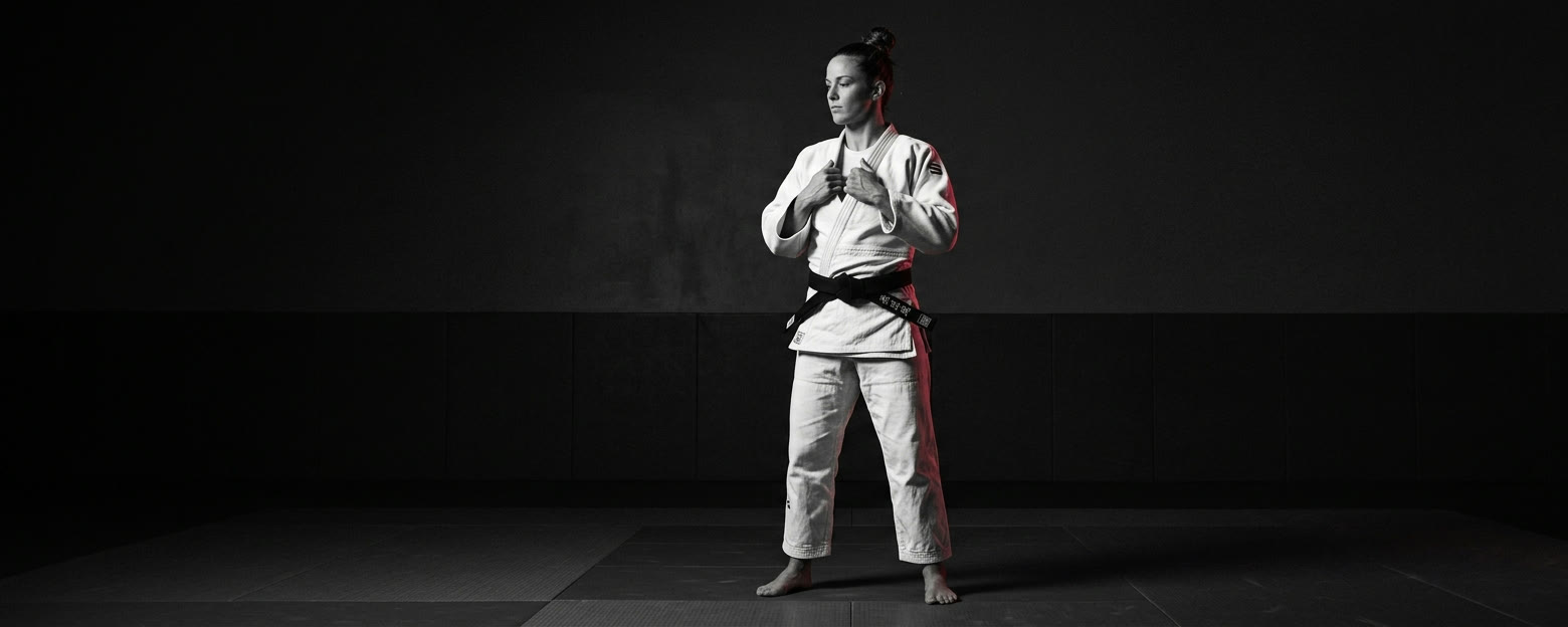 Judoka en kimono blanc ajustant son gi sur le tatami